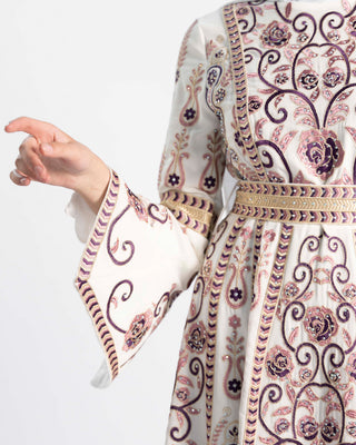 Close-up of purple and gold tatreez embroidery and a bell-sleeve cuff on an ASHI Palestinian kaftan
